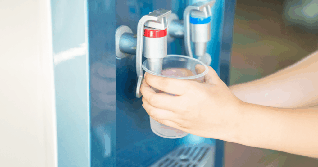ウォーターサーバーから温水を注ぐ手。