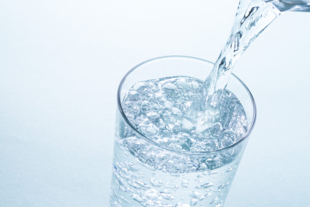 ガラスのコップに水を注いでいる様子