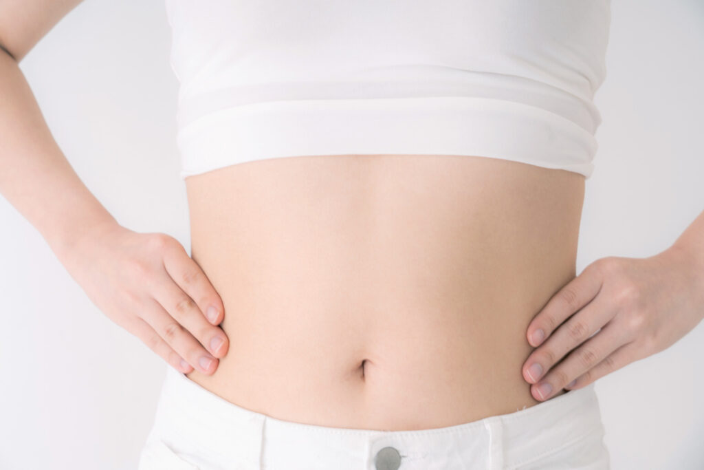 お腹を出している女性が腰に手をあてている様子