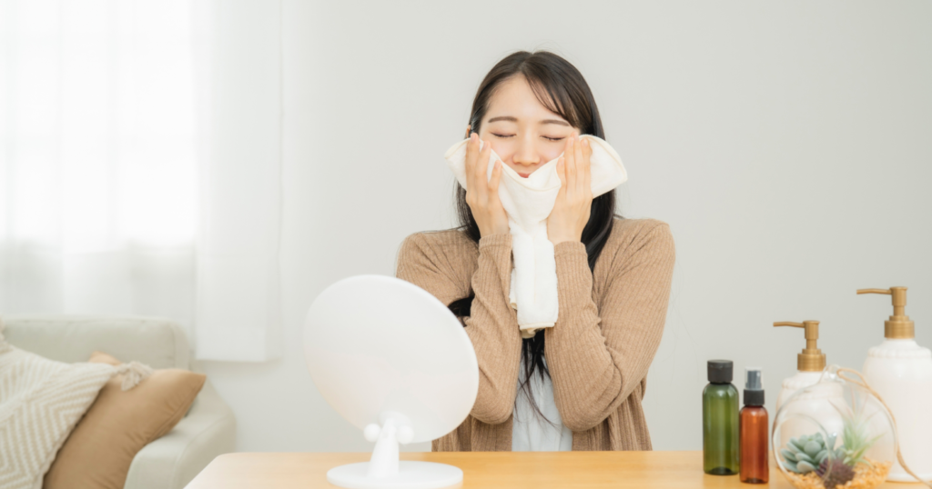 女性が白い蒸しタオルを顔にあてている様子