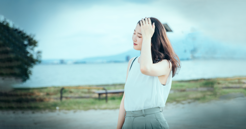 外を歩く頭痛の女性