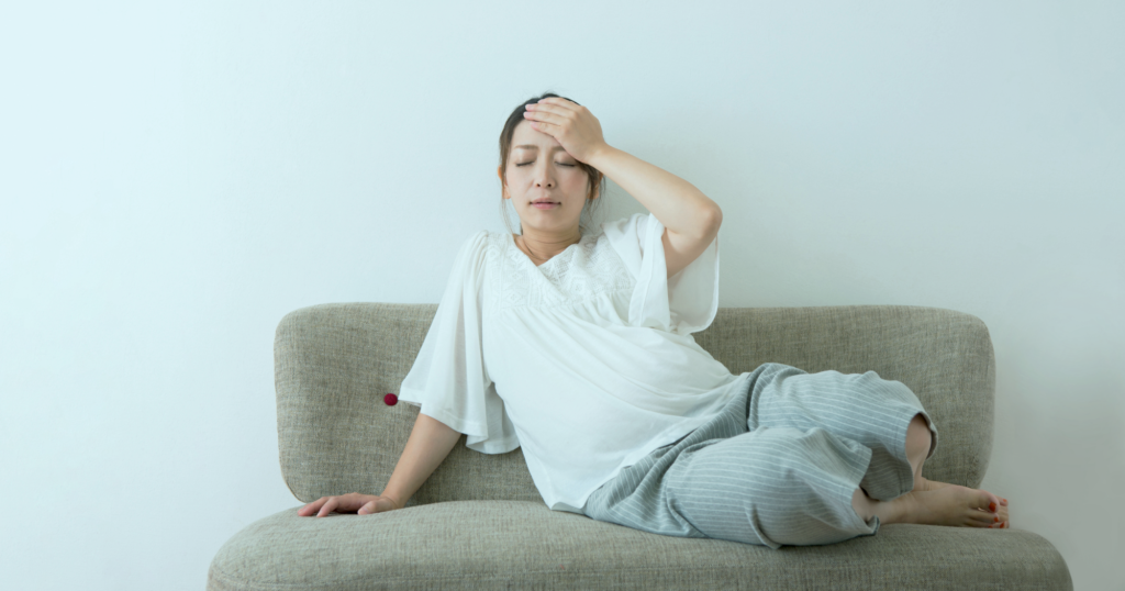 ソファにもたれかかる頭痛の女性
