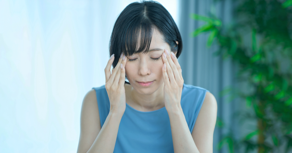リビングデうつむく頭痛の女性