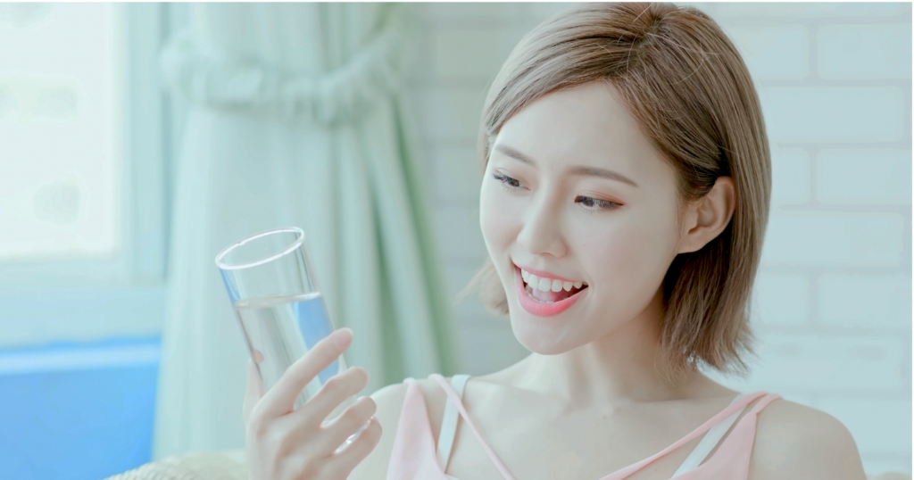部屋で美味しい水を飲む女性