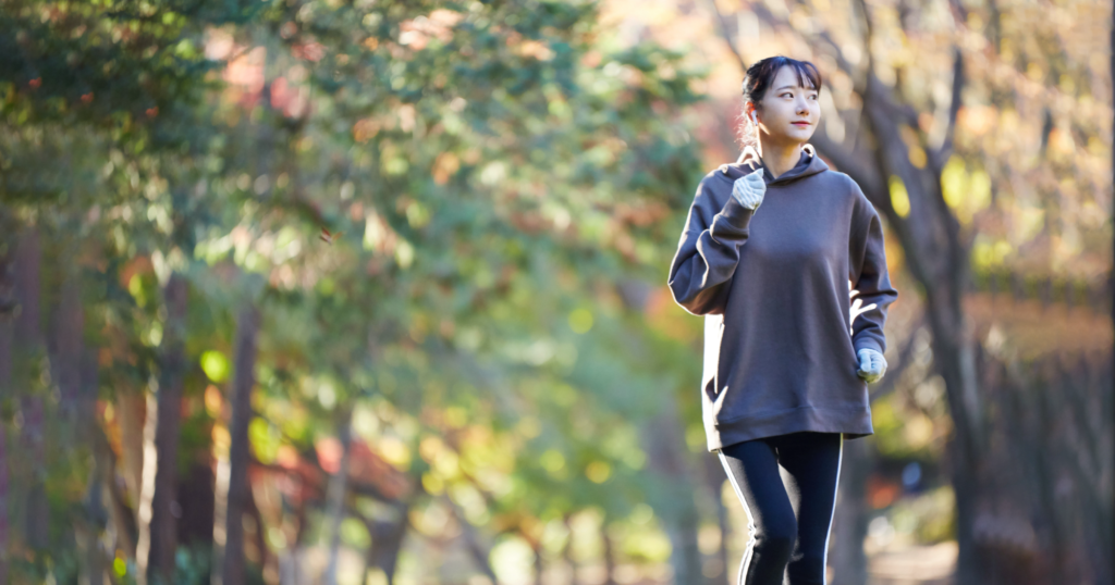 女性が街路樹でジョギングしている図
