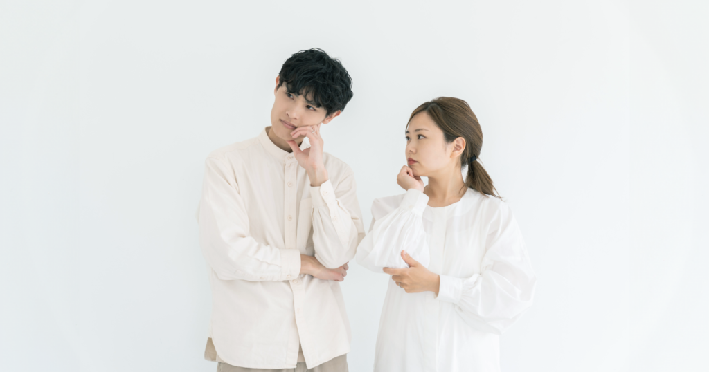 男女が並んで立ち、考える様子